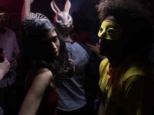 People wearing costumes, dancing in night club